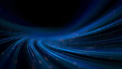 Long blue light trails curve toward a vanishing point in deep black space.