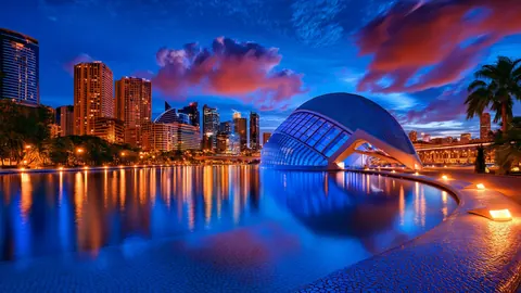 A futuristic bay skyline gathers around a luminous dome.