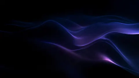 A thin indigo veil drifts in soft folds through the dark, barely lit along its edges.