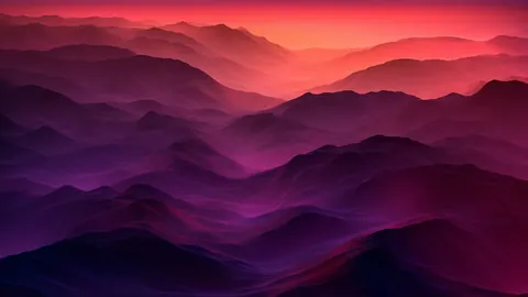 Rows of soft ridges fade from deep purple to pink under a warm glowing sky.