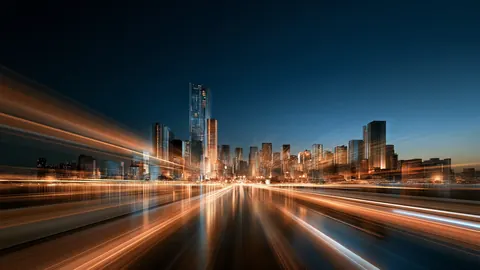 Desktop wallpaper of a city skyline at dusk with streaking orange light trails.
