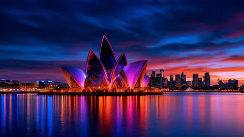 Petal-like pavilion forms glow pink and orange beside a harbor.