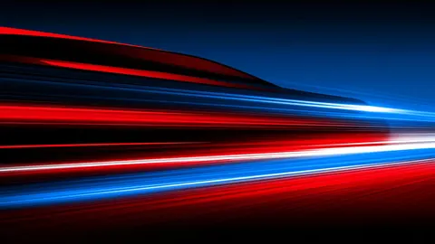 Long red and blue light streaks race horizontally across a dark background.