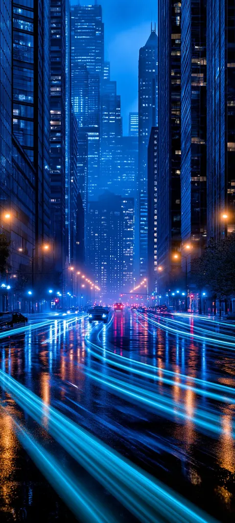 Wet neon streets streak with blue and orange traffic light as towers climb into the night.