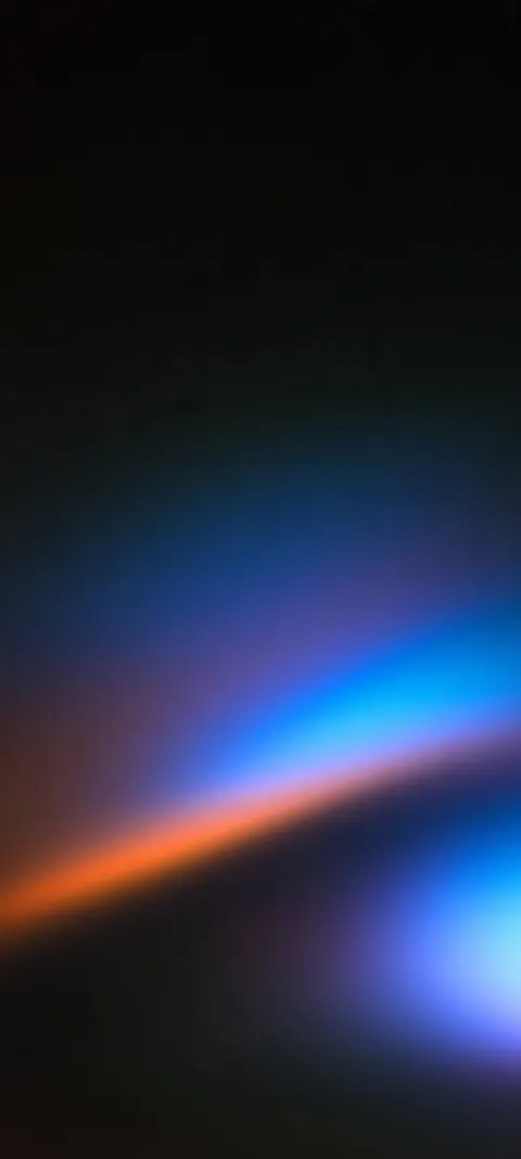 Soft streaks of orange, blue and purple refract across a dark textured field.